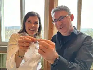 Ein Mann und eine Frau lächeln und halten einen Schlüssel in der Hand, der den Beginn eines neuen Lebensabschnitts symbolisiert.